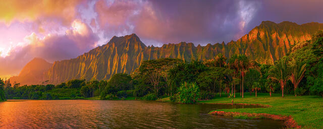Early morning sunrise over the fluted peaks of the Koolau mountains reflecting in a calm lake at Hoomaluhia Botanical Garden on Oahu. (